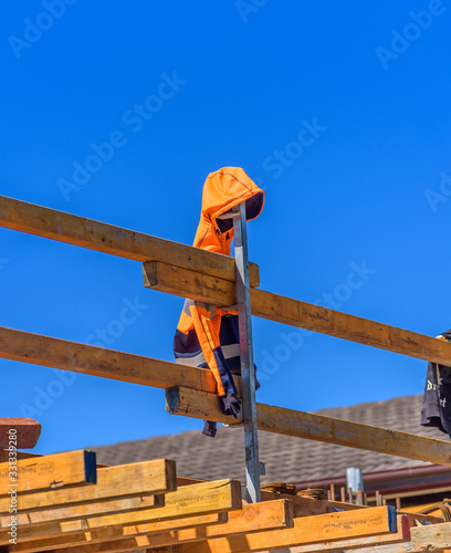 A construction worker has left their high visibility jacket on a saftey railing