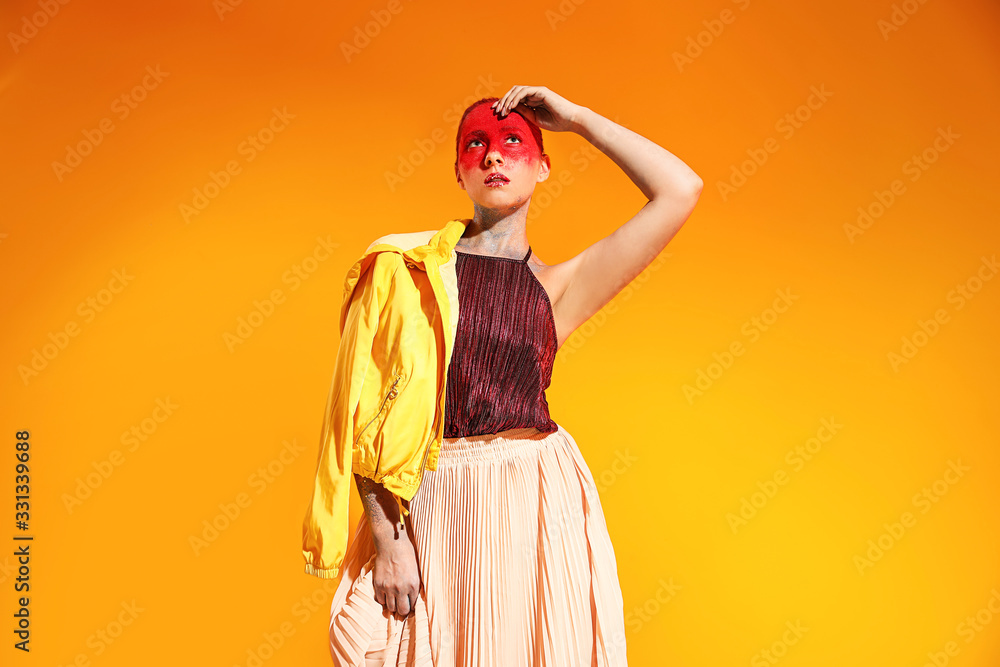 Beautiful woman with unusual makeup on color background