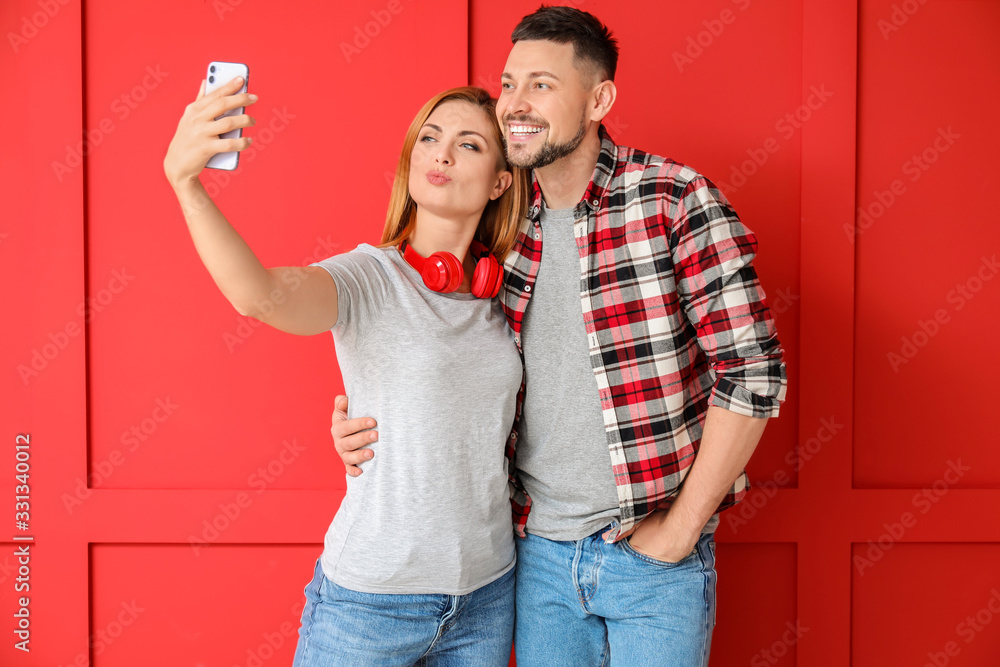 Obraz premium Couple taking selfie on color background