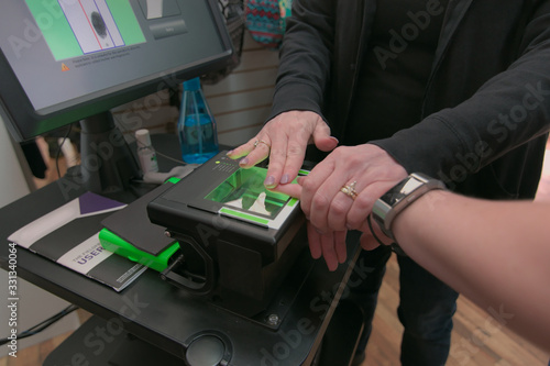 Foto A young woman gets her finger prints scanned live as a requirement to getting a job as a travel occupational therapist