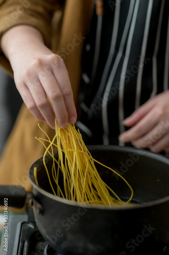 Fototapeta Cropped shot of young woman preparing ingredients for noodle menu