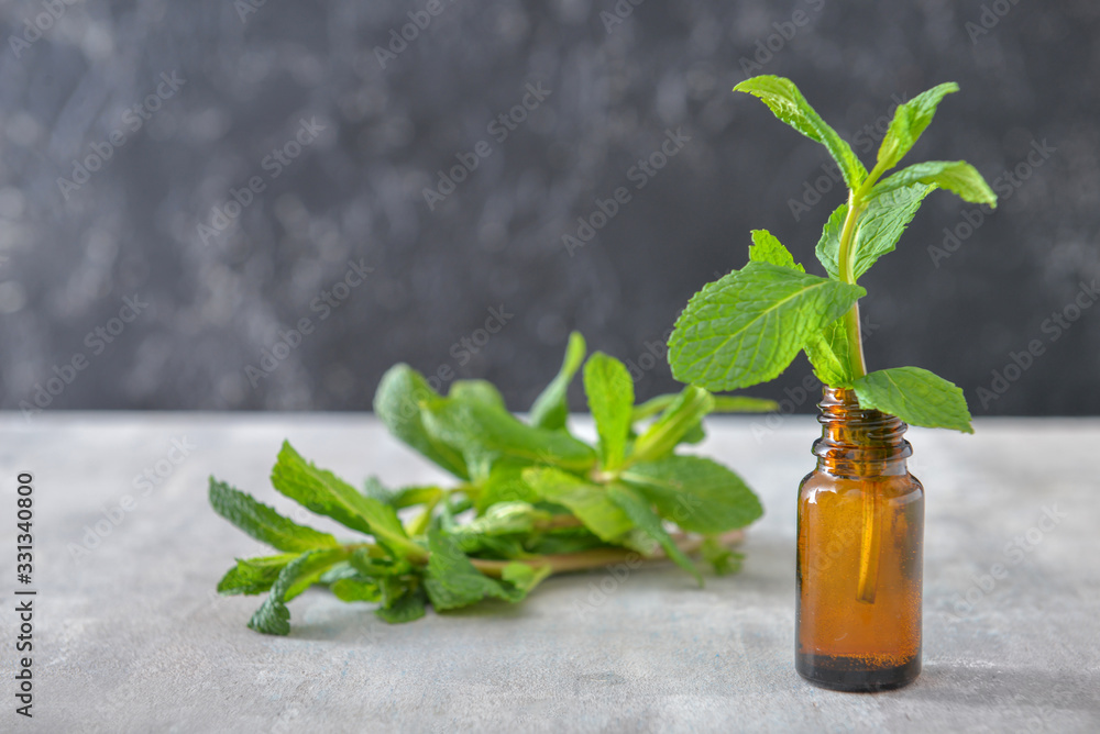 Bottle of mint essential oil on table Bottle of mint essential oil on table