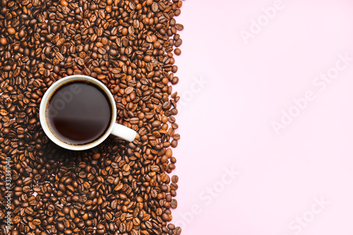 Fototapeta Naklejka Na Ścianę i Meble -  Cup of hot coffee and beans on color background