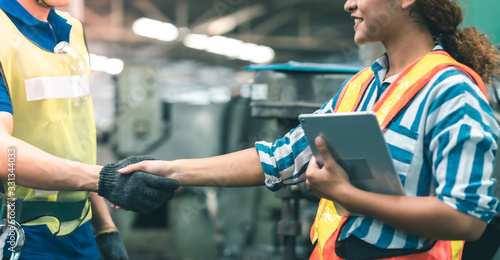 Industrial Engineers in Hard Hats.Work at the Heavy Industry Manufacturing Factory.industrial worker indoors in factory.aged man working in an industrial factory.meeting  and shakehand in factory. photo