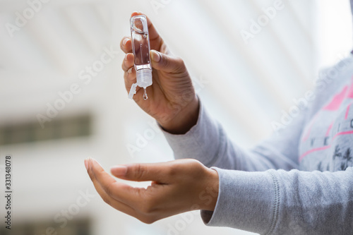 Protection from Coronavirus and germs. Female hands squeezing antibacterial hand sanitizer bottle.