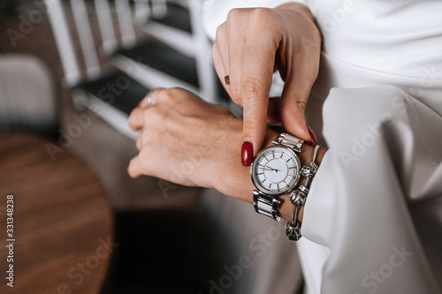 Beautiful women's hands touch the watch. a woman checks the time on her watch. women's hands close -up. Silver watch on a woman's hand