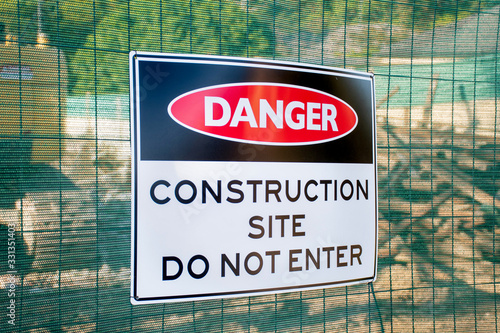 Danger Construction site do not enter sign on a fence surrounding the demolished buiding