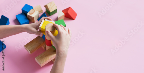 A child plays assemble with wooden cubes constructor. Education concept for children learning. Children's toys