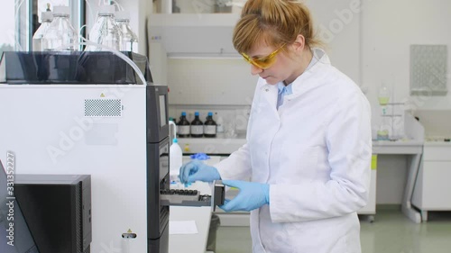 Scientist taking cbd samples from chromatography machine in laboratory