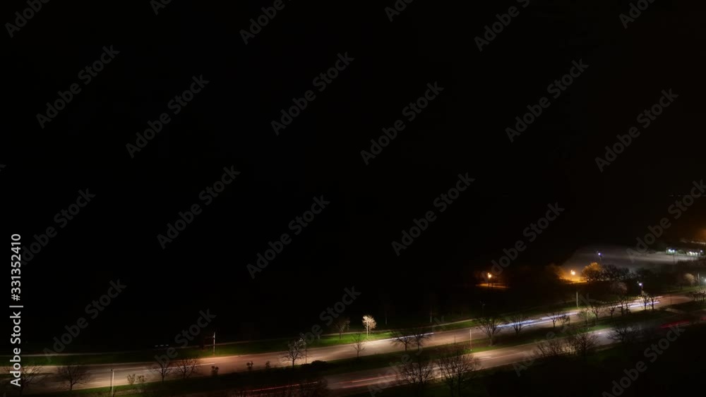 Timelapse of vehicle traffic light trails from headlights and tail lights on Lake Shore Drive at night as lights from airplanes pass overhead creating copy space in dark night sky over Lake Michigan. Timelapse of vehicle traffic light trails from headlights and tail lights on Lake Shore Drive at night as lights from airplanes pass overhead creating copy space in dark night sky over Lake Michigan.