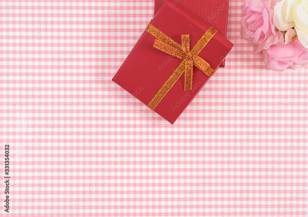 gift box with red isolated on Plaid background. Holiday decoration for Mother's Day or Women's Day. gift box with red isolated on Plaid background. Holiday decoration for Mother's Day or Women's Day.