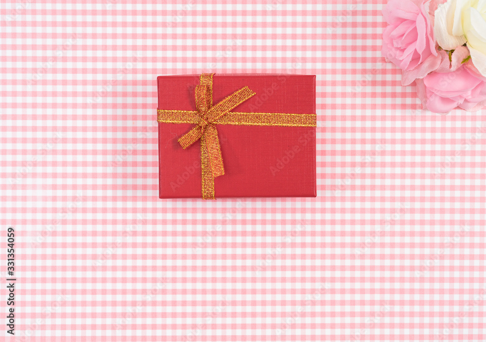 gift box with red isolated on Plaid background. Holiday decoration for Mother's Day or Women's Day. gift box with red isolated on Plaid background. Holiday decoration for Mother's Day or Women's Day.