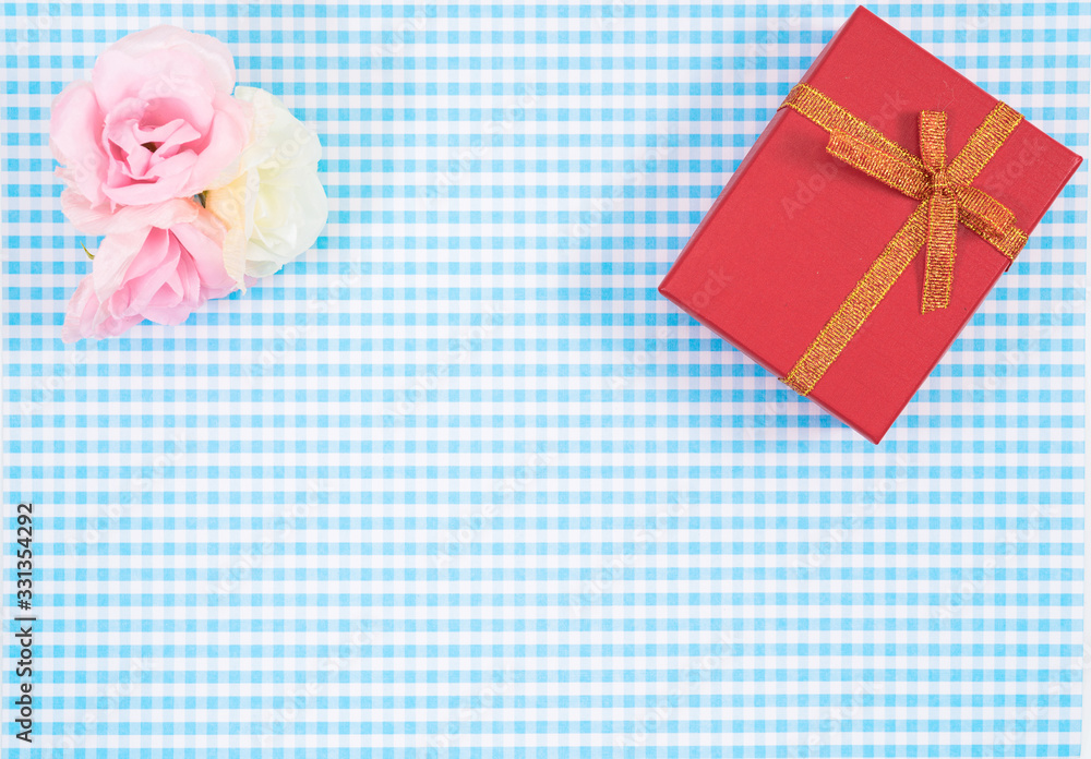 gift box with red isolated on Plaid background. Holiday decoration for Mother's Day or Women's Day. gift box with red isolated on Plaid background. Holiday decoration for Mother's Day or Women's Day.