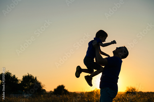 Father and son playing in the park at the sunset time. © altanaka