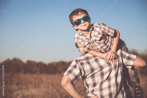 Father and son playing on the field at the day time.