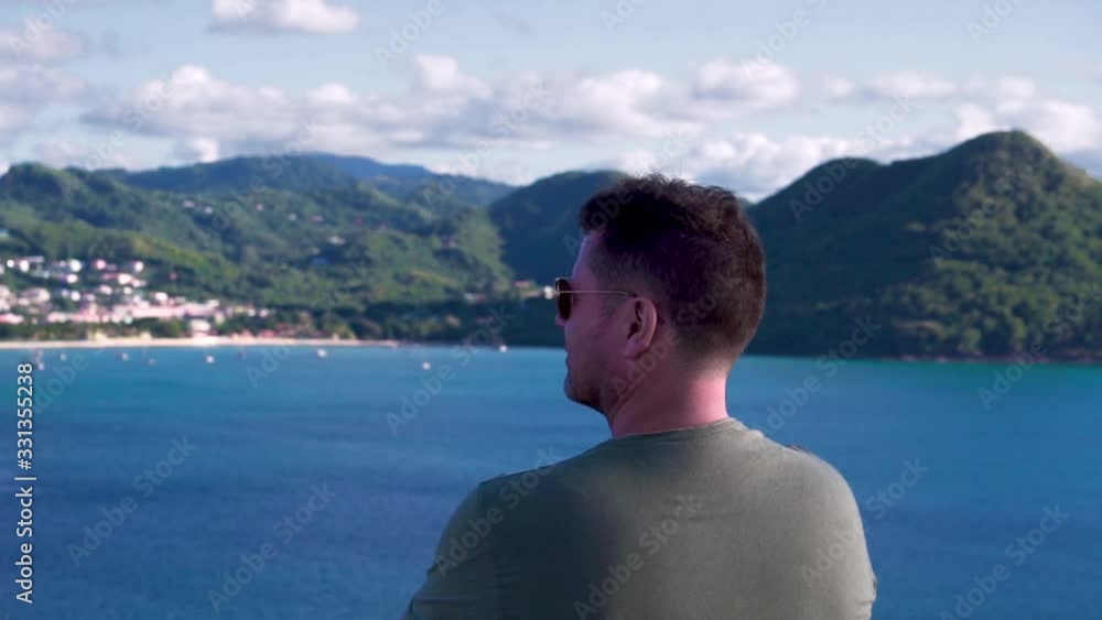 Man enjoying scenic view of St. Lucia, Rodney Bay, watching over city and seascape with mountains 