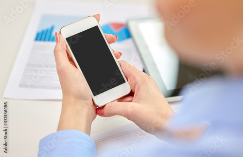 business, technology and people concept - close up of woman with smartphone at office