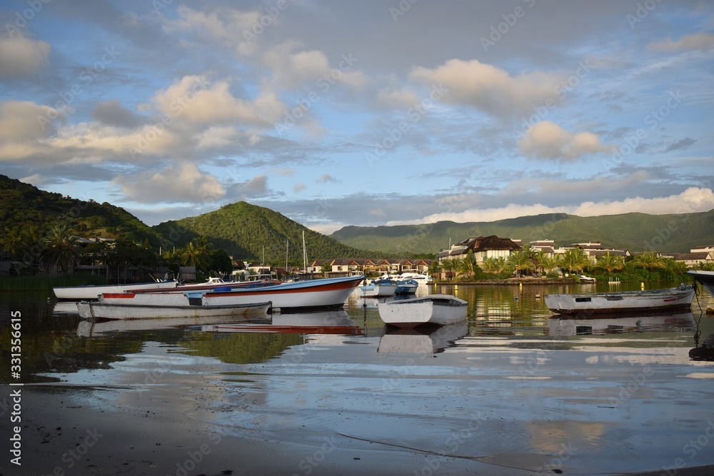 Beautiful and calm bay of water with wooden fishing boats. Fantastic natural light and background with mountains.