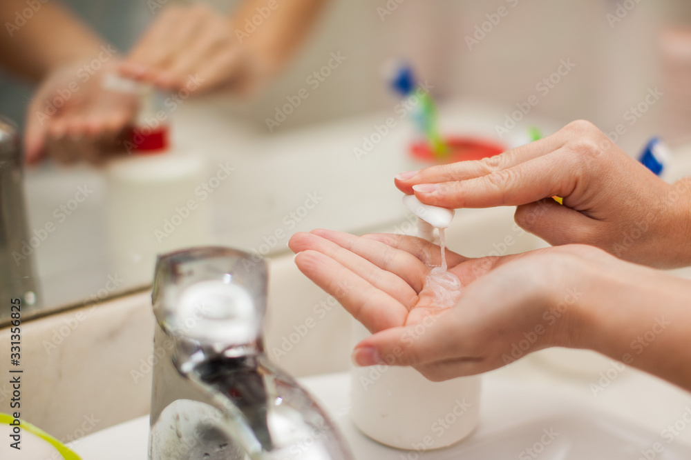 Woman antibacterial liquid soap for hands in bathroom. People and healthcare concept. Woman antibacterial liquid soap for hands in bathroom. People and healthcare concept.