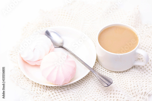 marshmallows, tea or coffee with milk and a tulip flower. on a light background. delicate breakfast, breakfast in bed. for the beloved. Surprise.