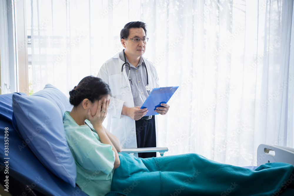 The doctors are asking and explaining about the illness to a female patient lying in bed at a hospital. The doctors are asking and explaining about the illness to a female patient lying in bed at a hospital.
