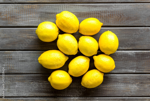 Ripe lemons - whole fruits - on wooden table top-down