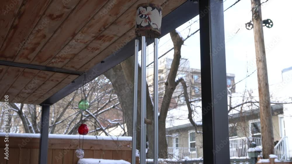 An object that makes noise under the effect of wind. Around you can see the snow and building.