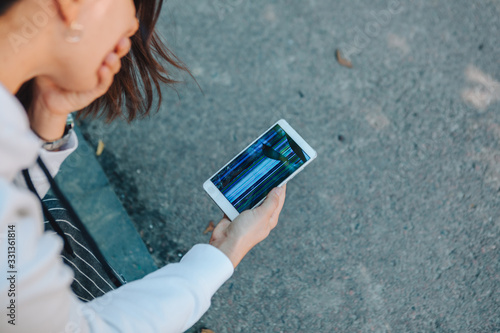 hands holding phone with broken cracked screen