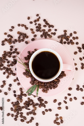 A Cup of strong black coffee surrounded by coffee beans in pastel, monochrome colors