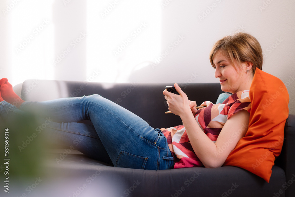 Obraz premium Texting with smartphone: young attractive girl is texting with her boyfriend