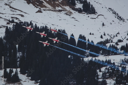 LES DIABLERETS, SWITZERLAND, 10.1.2020: Patrouille Suisse formation display team of the Swiss Air Force flying Northrop F-5E fighter aircraft over the alps close to Les Diablerets. photo