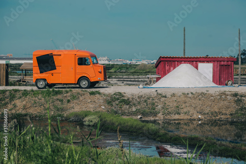 Old timer truck in orange color is collecting salt on a salt plantation in Portugal
