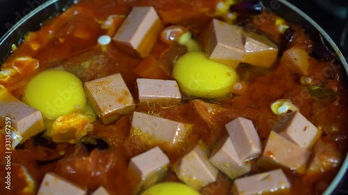 slow motion top shot of a raw breakfast in a boiling pan photo