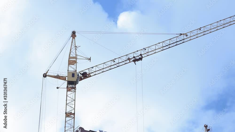 Construction the buildings. Construction Process of on the roof and clouds on a blue sky. Construction the buildings. Construction Process of on the roof and clouds on a blue sky.