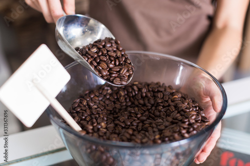 Seller is pouring coffee from glass container