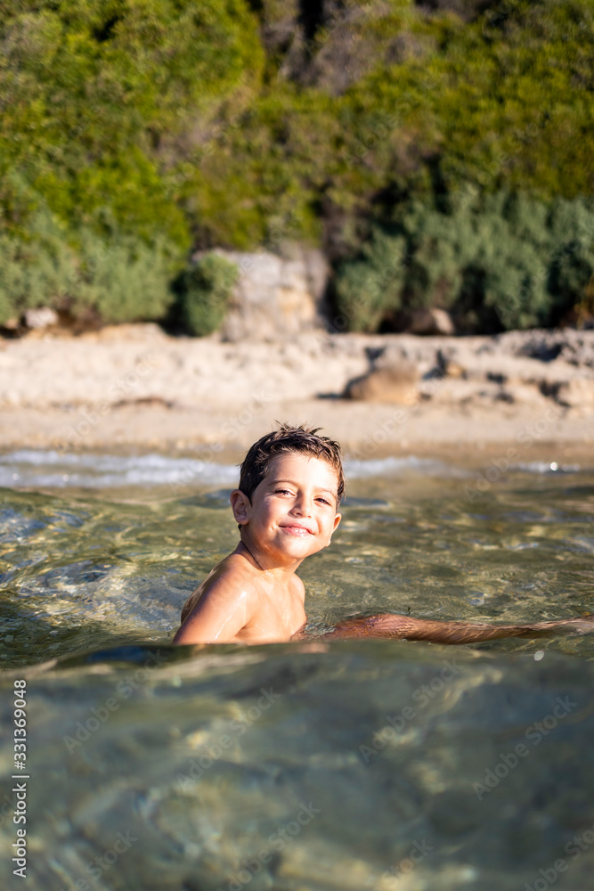 Fototapeta premium Funny child swimming on the sea