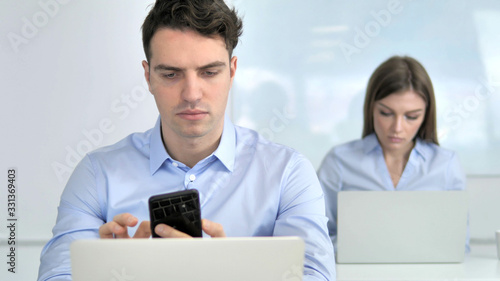 Businessman Using Smartphone at Work © stockbakers