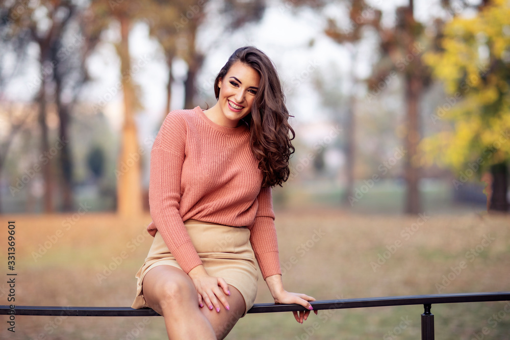 Portrait of young beautiful woman and she is sitting on fence Portrait of young beautiful woman and she is sitting on fence