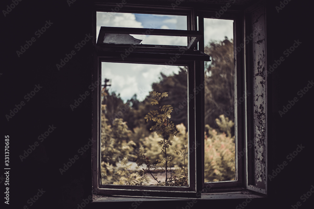 Fototapeta premium Dark room in an abandoned ruined building. Light from a window