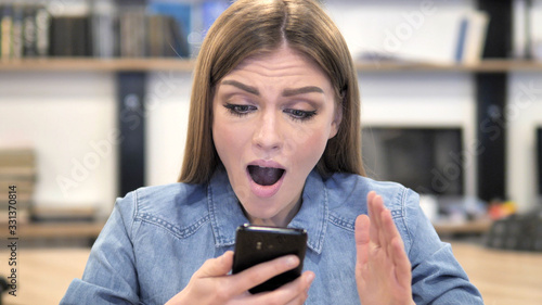 Young Woman Excited for Success while Using Smartphone