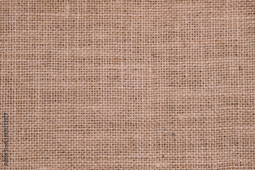 Rough hessian background with flecks of varying colors of beige and brown. with copy space. office desk concept, Hessian sackcloth burlap woven texture background.