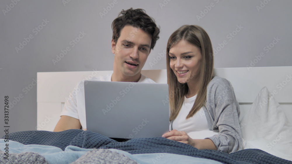 Happy Young Couple Using Laptop in Bed Happy Young Couple Using Laptop in Bed