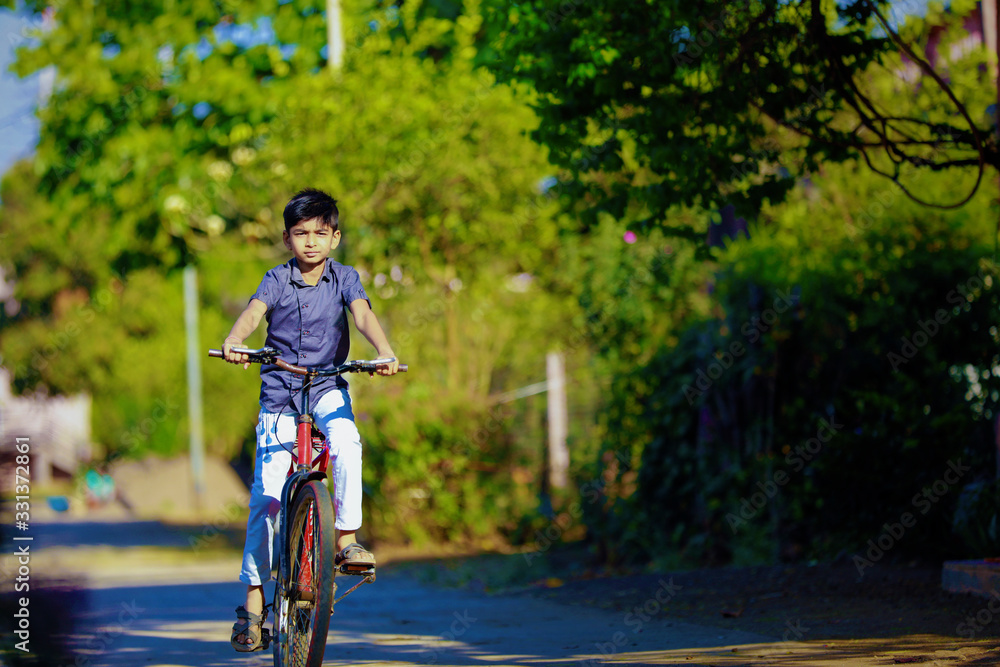 Obraz premium indian / Asian little boy enjoy cycle riding