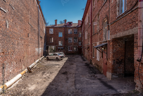 The courtyard of an old brick apartment building abandoned since Great Patriotic War (1941-1945) (World War II). Inscription in Russian: "Shelter". Rybinsk, Yaroslavl region, Russia