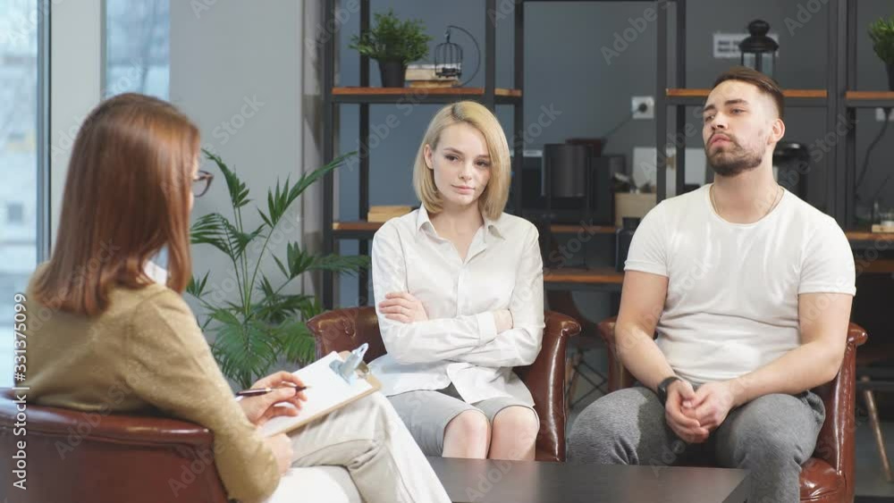 Young modern married couple offended by each other sit telling their problems to family psychologist, they want to get advice and possible solutions to the problem. Family, couple, relationships Young modern married couple offended by each other sit telling their problems to family psychologist, they want to get advice and possible solutions to the problem. Family, couple, relationships