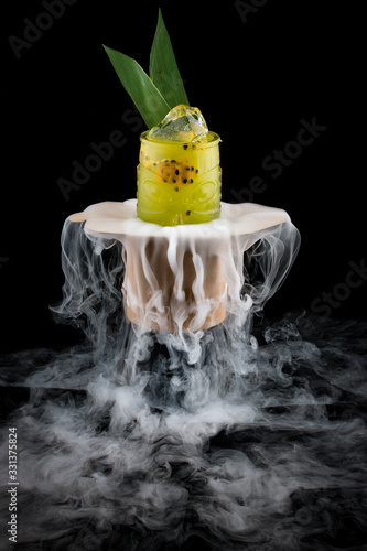 Cold mango lemonade surrounded by smoke on a dark background