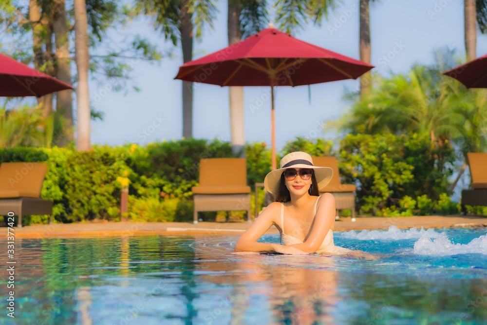 Portrait beautiful young asian woman relax around swimming pool in hotel resort