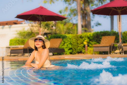 Portrait beautiful young asian woman relax around swimming pool in hotel resort