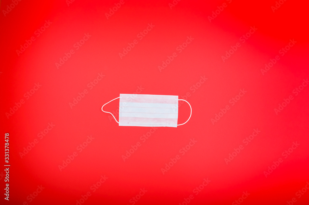 Coronavirus. New pandemic Covid 2019 and 2020.A protective mask against viruses, on a large red background. Top view. free space for text. Copy space. Flat lay Coronavirus. New pandemic Covid 2019 and 2020.A protective mask against viruses, on a large red background. Top view. free space for text. Copy space. Flat lay