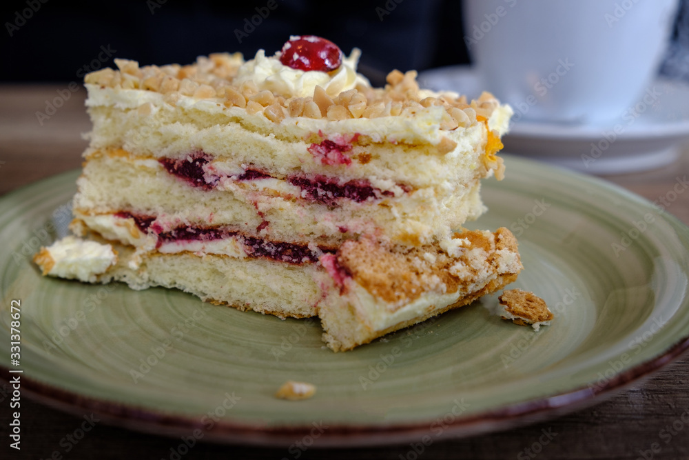 A slice of a soft hazelnuts cake filled with cream and black cherries, served for breakfast. A slice of a soft hazelnuts cake filled with cream and black cherries, served for breakfast.